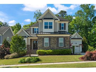 Beautiful two-story home featuring stone accents, manicured landscaping, and a charming covered entryway at 3029 Mountain Hill Dr, Wake Forest, NC 27587