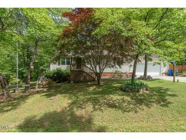 Charming single-Gathering home with a well-manicured lawn and mature trees at 306 N Sixth St, Mebane, NC 27302