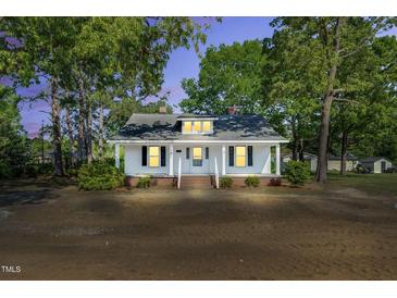 Charming single-story home with mature trees, inviting front porch, and a classic design at 310 Chicopee Rd, Benson, NC 27504