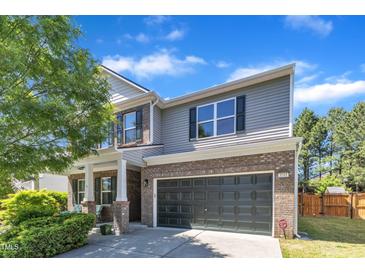 Charming two-story home boasts a brick and siding exterior, complemented by a well-manicured lawn and a two-car garage at 3801 Althorp Dr, Raleigh, NC 27616