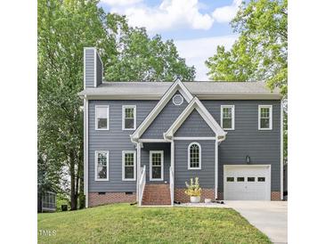 Charming two-story home featuring a gray exterior, brick foundation, and attached one-car garage at 404 Cary Pines Dr, Cary, NC 27513
