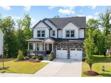 Charming two-story home with stone accents, a covered porch, and a well-manicured lawn at 521 Marion Hills Way, Knightdale, NC 27545