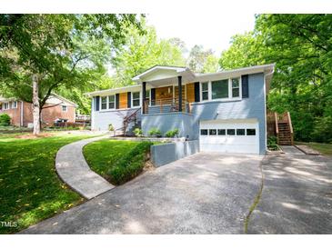 Charming home with a blue painted brick exterior, wooden accents, and an attached garage at 529 Orindo Dr, Durham, NC 27713