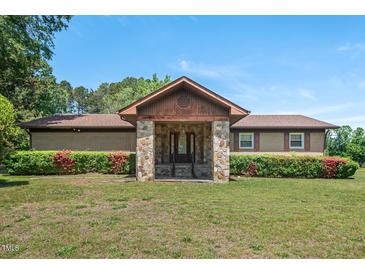 Charming single-story home featuring a stone entrance and lush landscaping at 620 Mcghees Mill Rd, Roxboro, NC 27574
