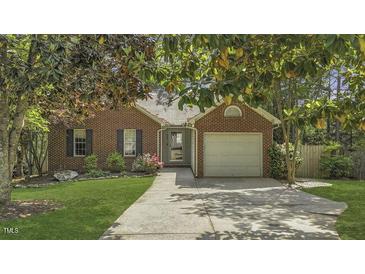 Charming brick home with mature trees, a well-maintained lawn, and a convenient two-car garage at 900 Finchurch Cir, Wake Forest, NC 27587