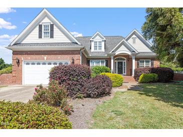 Charming brick home with manicured landscaping and a two-car garage, showcasing curb appeal at 97 Rand Rd, Raleigh, NC 27603