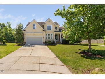 Charming yellow two-story home featuring a well-maintained lawn, two-car garage, and a welcoming front porch at 9701 Precious Stone Dr, Wake Forest, NC 27587