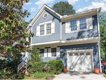 Charming two-story home with blue siding, white trim, and a two-car garage at 102 Martins Point Pl, Cary, NC 27519