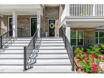 Welcoming front entrance with white stairs, black railings, and a charming brick facade at 11549 Helmond Way # 107, Raleigh, NC 27617