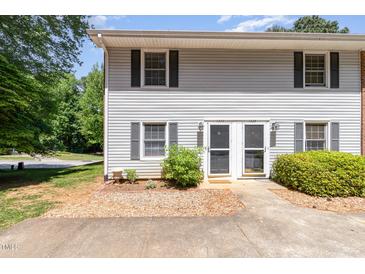 Charming townhouse exterior with light gray siding, black shutters and a well-maintained front yard at 1223 Jamestown Ct, Cary, NC 27511
