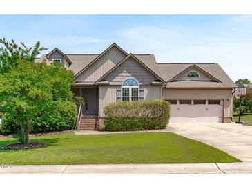 Charming home featuring a landscaped yard, attached garage, and inviting front entrance at 124 Willa Chase Ct, Benson, NC 27504