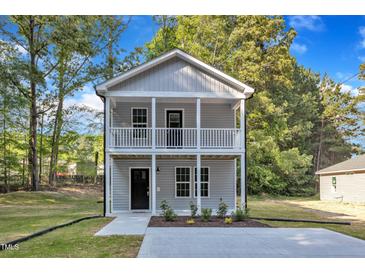 Charming two-story home with a welcoming front porch and neutral gray siding at 129 Davis St, Louisburg, NC 27549