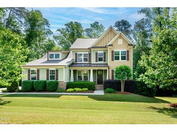 Charming two-story home featuring a well-manicured lawn and lush landscaping at 1820 Yates Wheel Way, Raleigh, NC 27606