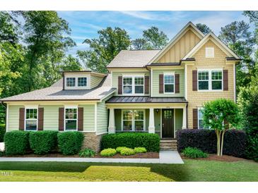 Charming two-story home featuring a well-manicured lawn and inviting curb appeal with lush landscaping at 1820 Yates Wheel Way, Raleigh, NC 27606