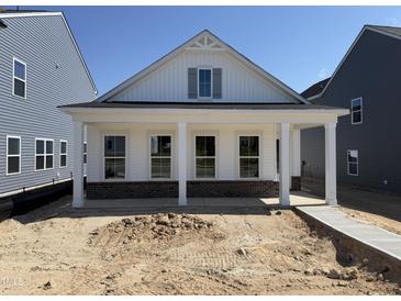 New construction home with brick facade and a charming front porch featuring classic white columns at 2874 Quarry Rd # 165, Rolesville, NC 27571