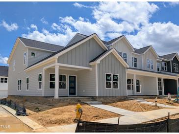 New construction, two-story home with vertical siding, covered porch and walkway on a sunny day at 2911 Alyssa Ct, Raleigh, NC 27604