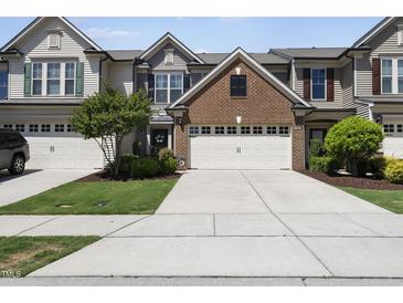 Well-manicured lawn and a two-car garage enhance this two-story townhome with beautiful curb appeal at 322 Brier Crossings Loop, Durham, NC 27703