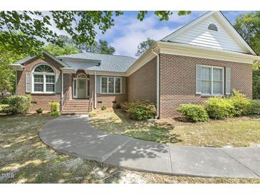 Charming brick home with a curved walkway and well-maintained landscaping at 3404 Apple Meadow Dr, Fuquay Varina, NC 27526