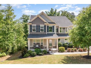 Charming two-story home featuring a welcoming front porch and professionally landscaped yard at 3609 Jordan Shires Dr, New Hill, NC 27562