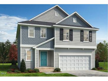 Charming two-story home featuring gray siding, black shutters, a turquoise front door and an attached garage at 368 Spelt Ct, Rolesville, NC 27571