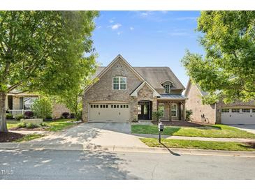 Charming brick home with a two-car garage, manicured lawn and stone accents, presenting inviting curb appeal at 4116 Argyle Trl, Burlington, NC 27215