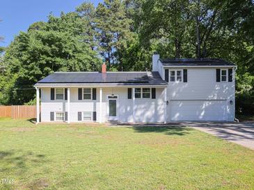 Charming two-story home with an attached garage, solar panels, and a well-maintained lawn at 4205 Woodlawn Dr, Raleigh, NC 27616