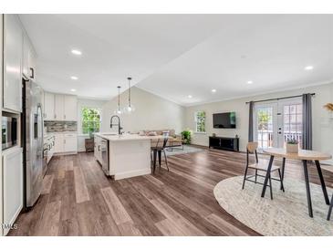 Open-concept living room and kitchen with hardwood floors and access to the outside at 4902 Cedar Glen Dr, Durham, NC 27713