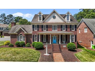 Charming two-story brick home with a blue front door, black shutters, and manicured landscaping at 5619 Bennettwood Ct, Raleigh, NC 27612