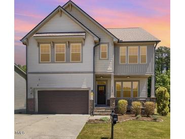 Charming two-story home featuring a cozy front porch, complemented by a well-maintained lawn at 7508 Channery Way, Raleigh, NC 27616