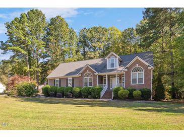 Charming home featuring a manicured lawn, brick accents, and a welcoming entrance at 100 Bradborne Cir, Clayton, NC 27520
