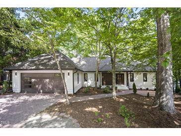 Charming single-story home with a brick driveway, attached garage, and a well-manicured front yard at 109 Lochview Dr, Cary, NC 27518
