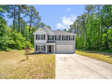 Charming two-story home with a concrete driveway and an attached two-car garage at 11 Mamie Ferguson Dr, Lillington, NC 27546