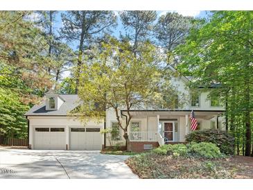 Charming two-story home with a three-car garage, landscaped yard, and inviting front porch at 112 Parkspring Ct, Cary, NC 27519
