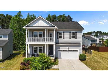 Charming two-story home featuring a double-decker porch, neutral siding, and an attached two-car garage at 116 Chaseford Ct, Holly Springs, NC 27540