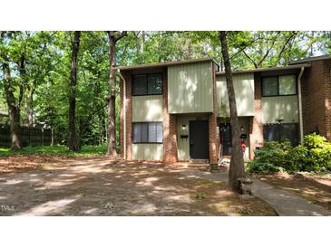 Charming two-story townhome with a brick facade and inviting front entrance nestled in a wooded setting at 1222 Teakwood Pl, Raleigh, NC 27606