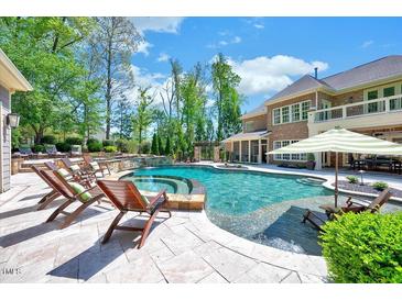 Luxury pool with lounge chairs, waterfall feature and beautiful landscaping at 187 Stoney Creek Way, Chapel Hill, NC 27517