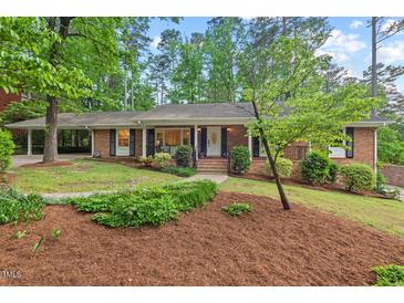 Charming brick home with a well-manicured lawn and mature trees creating an inviting curb appeal at 2508 Sevier St, Durham, NC 27705