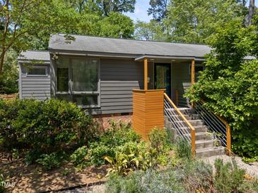 Charming home featuring stylish wood accents, gray siding, and beautifully landscaped front yard at 2529 Remington Rd, Raleigh, NC 27610