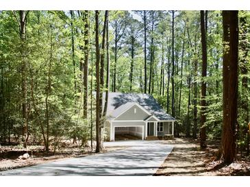 Charming home nestled in a wooded area, featuring a cozy front porch and attached carport at 3258 Yorkshire Cir, Sanford, NC 27332