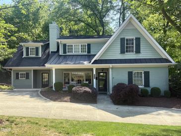 Charming two-story home with a manicured lawn, complemented by lush landscaping and a welcoming, quaint porch at 3504 Rock Creek Dr, Raleigh, NC 27609
