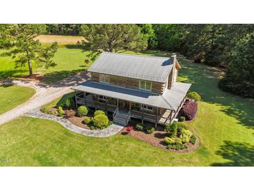 Stunning log home with metal roof, wrap-around porch, and beautiful landscaping at 407 Howard Tant Rd, Zebulon, NC 27597