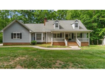 Charming home with a covered front porch, dormer windows, and a well-maintained lawn at 450 S Stratford Dr, Henderson, NC 27537