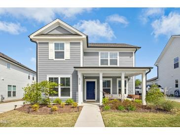 Charming two-story home featuring gray siding, a cozy front porch, and well-manicured landscaping at 5009 Megara, Raleigh, NC 27603