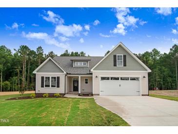 Inviting home exterior boasts a well-maintained lawn, attractive curb appeal, and an attached garage at 56 Birchtop Cir, Zebulon, NC 27597