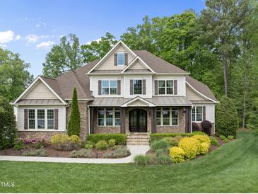 Charming two-story home featuring manicured landscaping and a welcoming front porch at 7312 Hasentree Way, Wake Forest, NC 27587