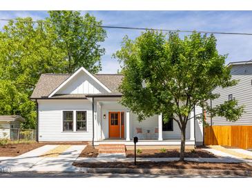 Charming cottage-style home with a covered front porch and vibrant orange front door at 107 N Guthrie Ave, Durham, NC 27703