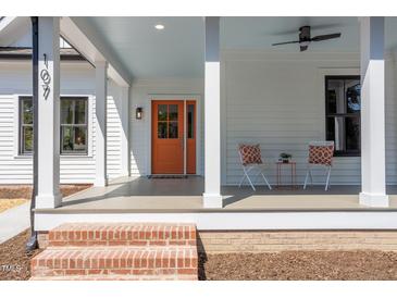Charming front porch with an orange door, white columns, and a seating area at 107 N Guthrie Ave, Durham, NC 27703