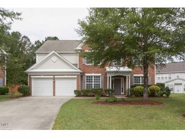 Charming two-story brick home featuring an attached two-car garage and a well-manicured lawn with mature trees at 110 Bristolwood Cir, Morrisville, NC 27560