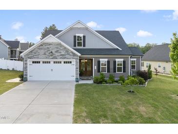 Charming two-story home featuring stone accents, a two-car garage, and a beautifully landscaped front yard at 110 Deacon Ridge Ln, Youngsville, NC 27596