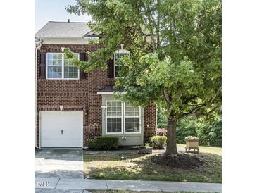 Charming brick townhome featuring a one-car garage and well-maintained front yard at 1909 Whirlaway Ct., Cary, NC 27519